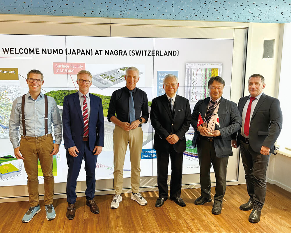 スイスのNAGRAマティアス・ブラウンCEO(左から3人目)とNUMO理事長 近藤(右から3人目)