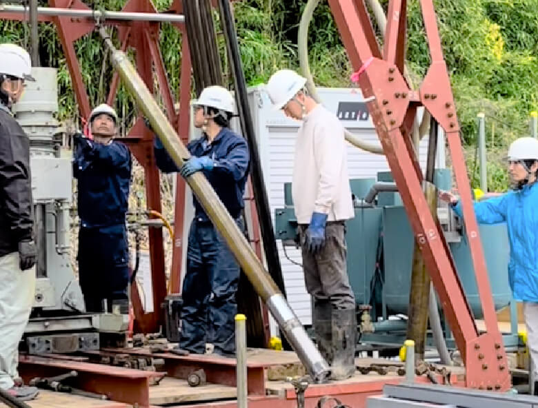 コア(岩石)の引き上げの様子を見守る技術部の若手職員(右)